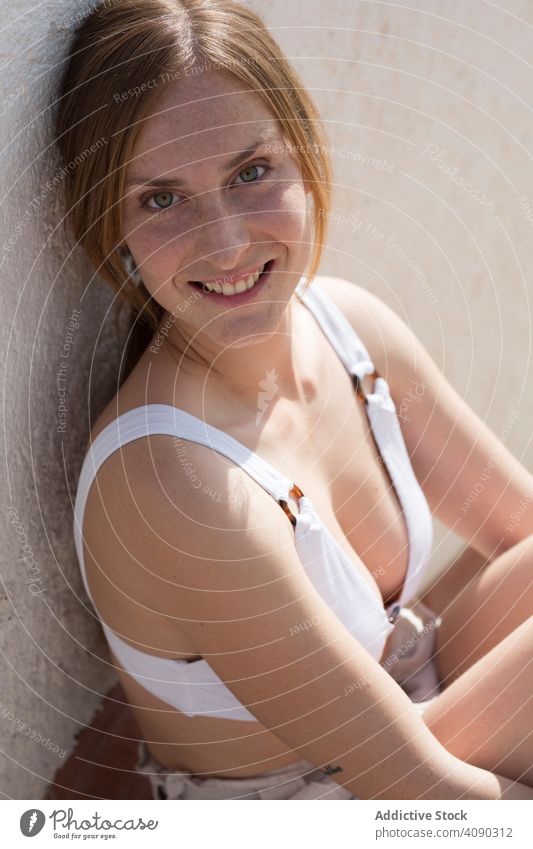 Woman relaxing near plaster railing woman sitting rest leaning resort sunny daytime female harmony idyllic young calm tranquil serene peaceful lifestyle leisure