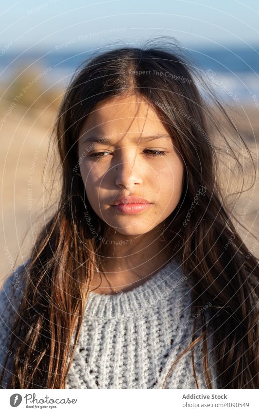 Smiling girl looking away on beach cheerful sky cloudless sunny bright daytime countryside kid child teen weather clear happy joy smiling long hair stylish