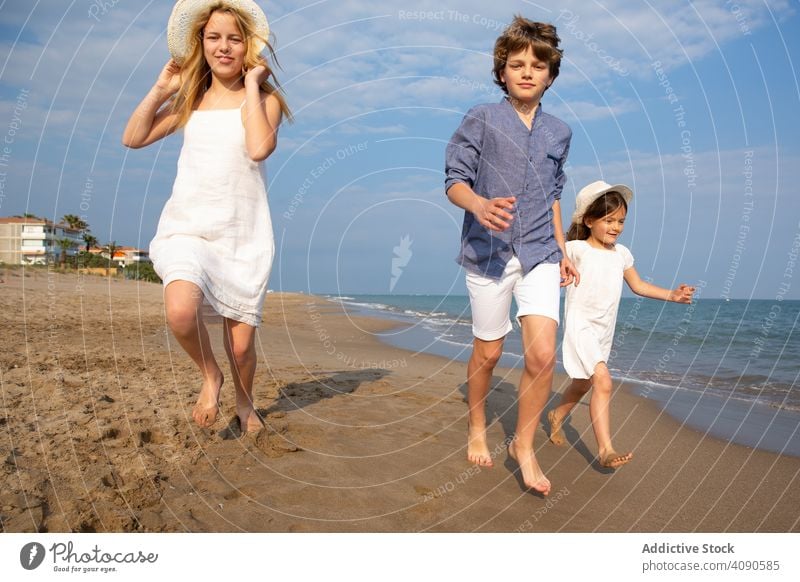 Kids running along seashore children beach summer vacation lifestyle happy ocean kids together happiness water sand people joy holiday beautiful childhood