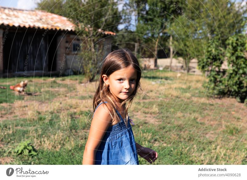 Little girl standing on farm yard summer vacation leisure holidays house beautiful nature happy field grass people country pretty rural cute child countryside