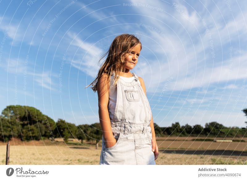 young girl posing in sunlight looking away confident summer nature stylish thoughtful child adorable expression vacation innocent childhood trendy style