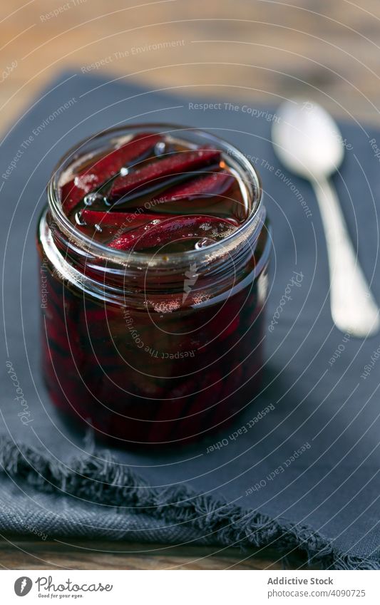 Sliced marinated red beet in glass jar sliced piece serving napkin spoon blue food beetroot vegetable vegetarian vegetation vegan juicy tasty meal healthy