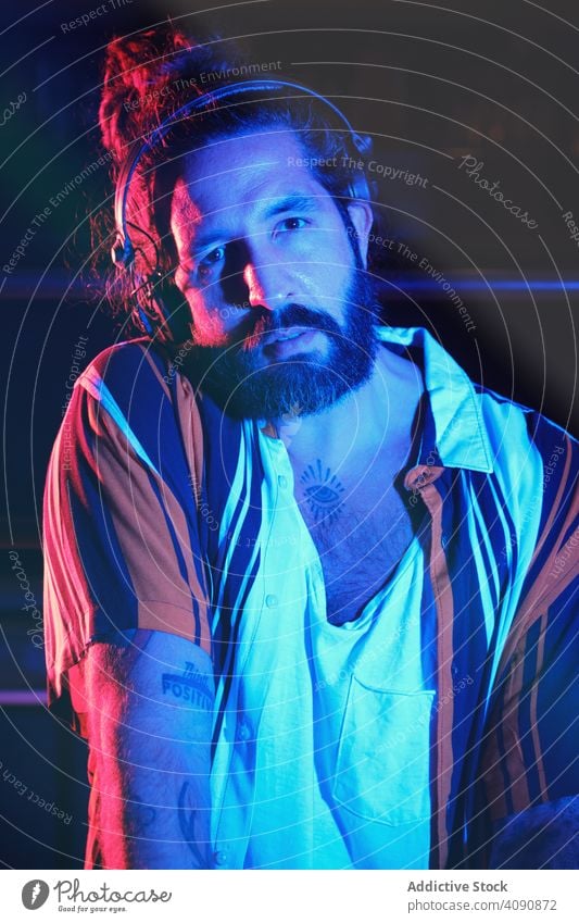 Bearded Dj man playing disco music in a club electronics discotheque crowd volume professional audio show mixer stereo sounds part headphone panel instrument dj