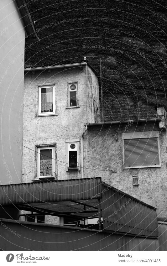 Run-down apartment building with old curtains and lowered roller shutter in the Mathildenviertel in Frankfurt am Main in Hesse, photographed in neo-realistic black and white