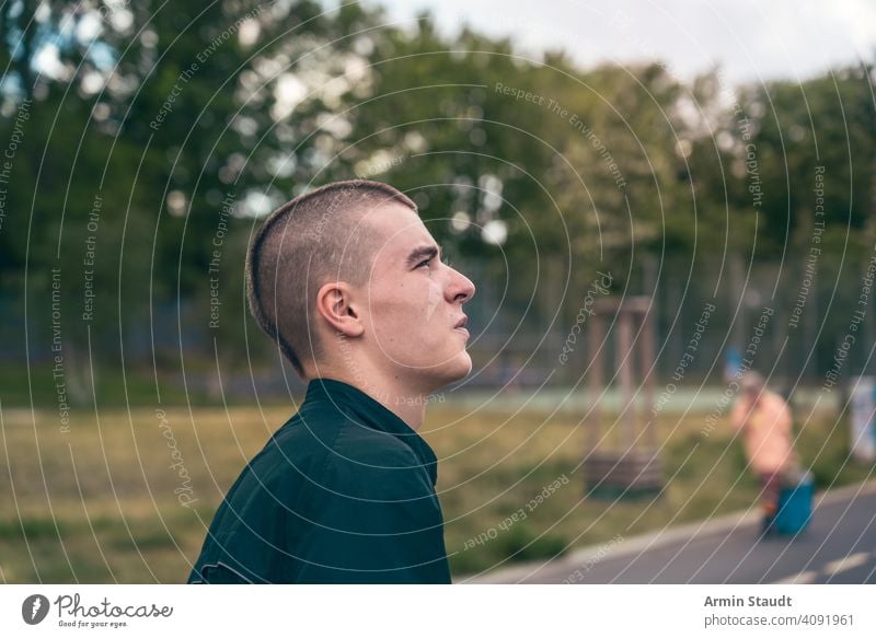 portrait in profile of a serious young man on the street teenager looking male beautiful casual caucasian outdoor confident model lifestyle journey trip travel