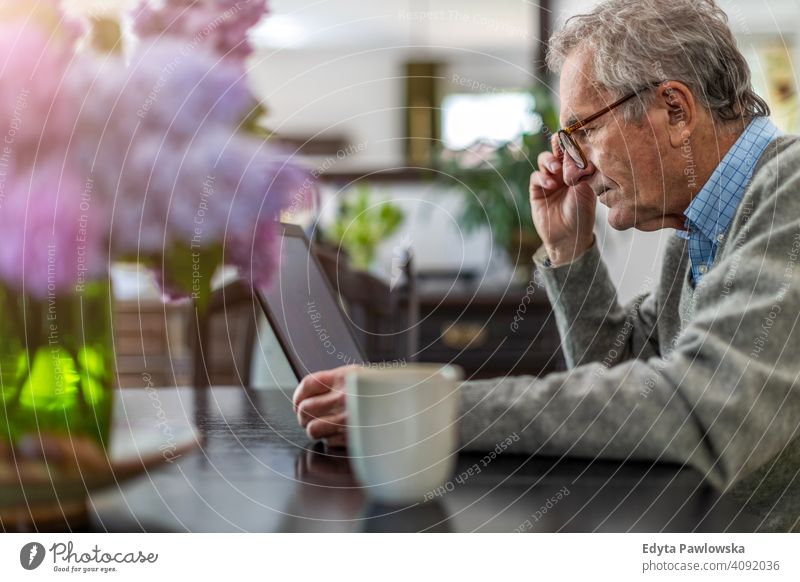 Senior man working on laptop at home senior elderly grandfather old pensioner retired retirement aged mature house male people lifestyle domestic life