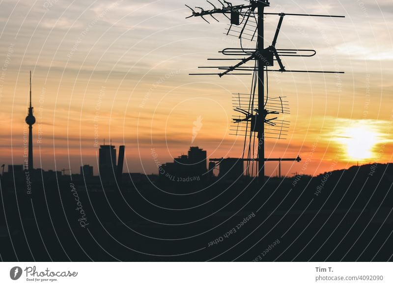 on a roof at sunset in Berlin . In the picture are an antenna and the Berlin TV tower Television tower Sunset Antenna tv tower Sky Berlin TV Tower Landmark