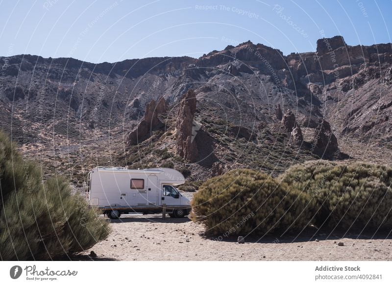 Camper on road against rocky mountains camper wild desert freedom caravan road trip tourism journey spain tenerife nature adventure bush landscape way traveling