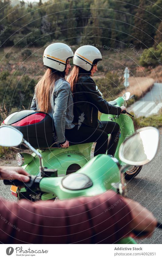 Young people riding motorcycles on city road helmet friendship scooter bike activity leisure street adventure travel enjoying transportation motorbike young