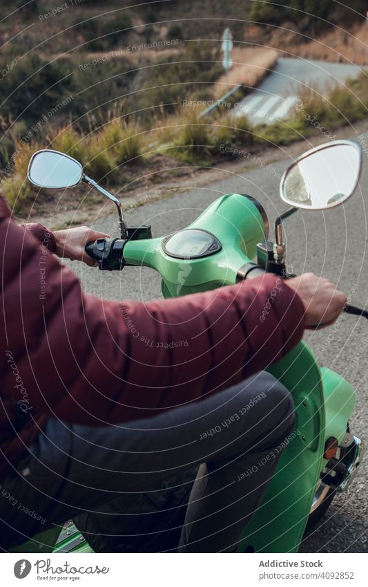 Man in warm jacket sitting on scooter holding wheel bike activity road leisure street adventure motorcycle travel enjoying transportation motorbike young