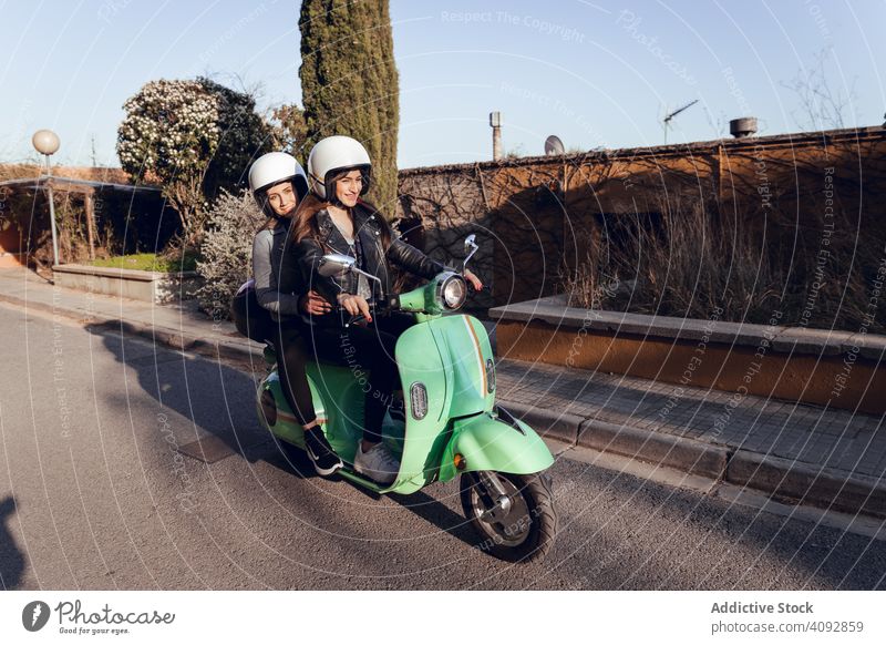 Young people riding motorcycles on city road helmet friendship scooter bike activity leisure street adventure travel enjoying transportation motorbike young