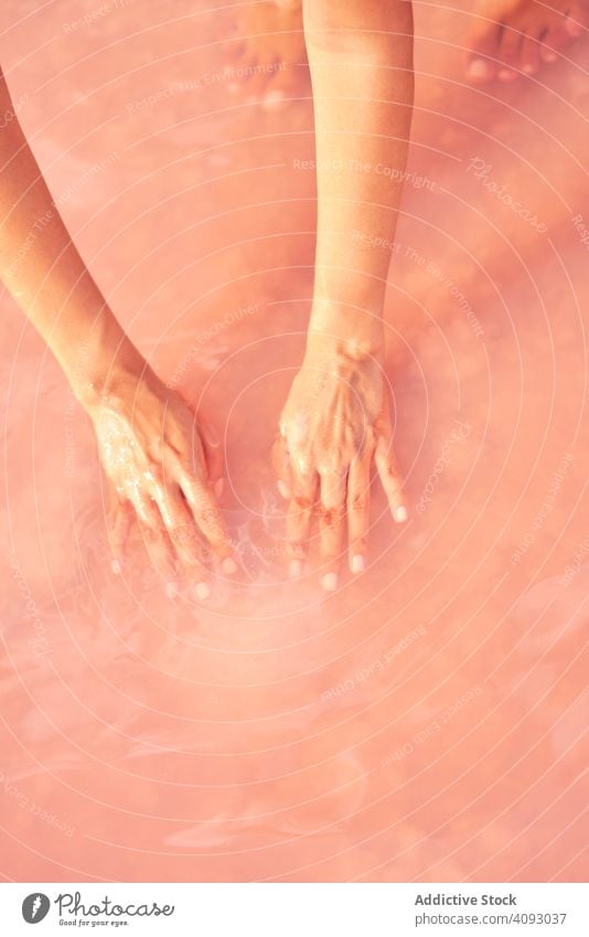 Female holding healing salt pile in pink water woman lake sea natural exotic red lagoon handful leisure heap therapeutic female beach holiday ocean travel