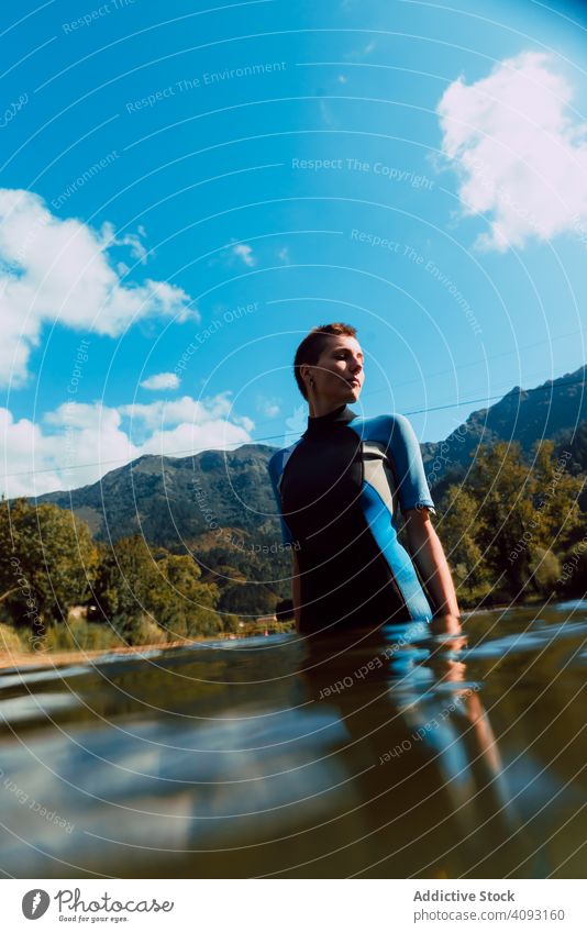 Young female in wetsuit standing in water woman sella river spain sport nature workout adventure tourism travel pensive serious athletic fit sportive young