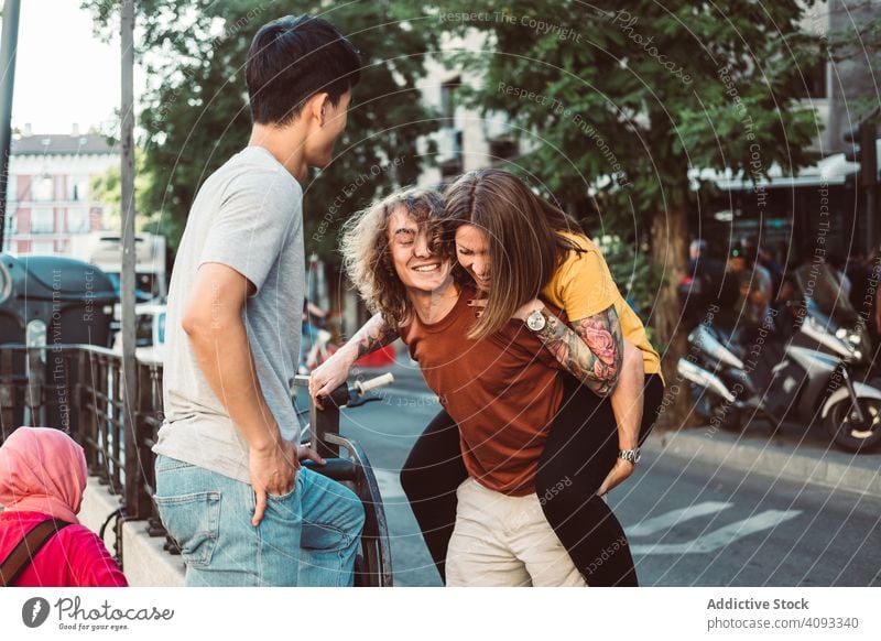 Carefree multiracial friends having fun on street piggyback playful carefree laugh stand city together summer diverse bonding happy friendship urban people