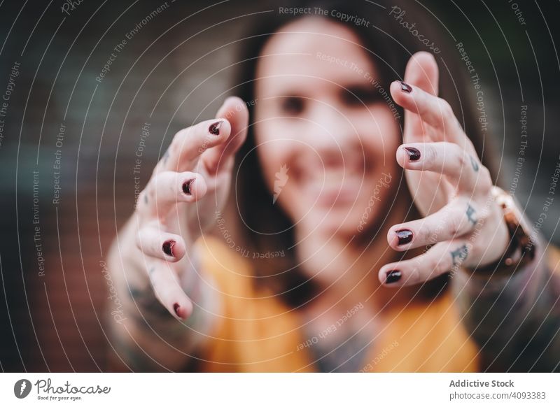 Smiling hipster woman stretching arms to camera on street give smile hand outstretch excited stand kind cheerful positive modern urban outstretched palm