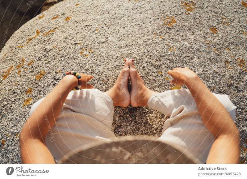 Person relaxing while sitting on stone meditation harmony shore sunlight zen warm practice moment bright peace power contemplate vacation peaceful freedom rock