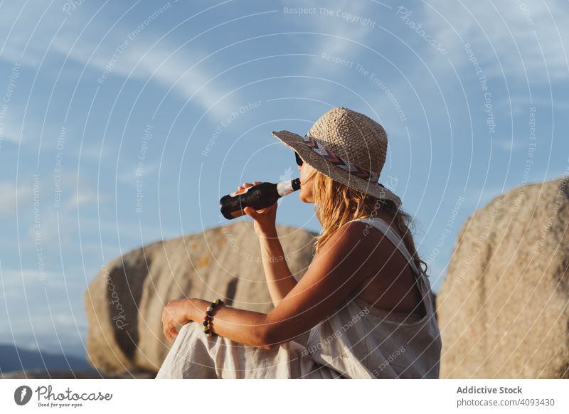 Woman relaxing and drinking beer at beach woman coast seaside lounge refreshment chill sunlight enjoy solitude bottle travel alcohol holidays trip vacation