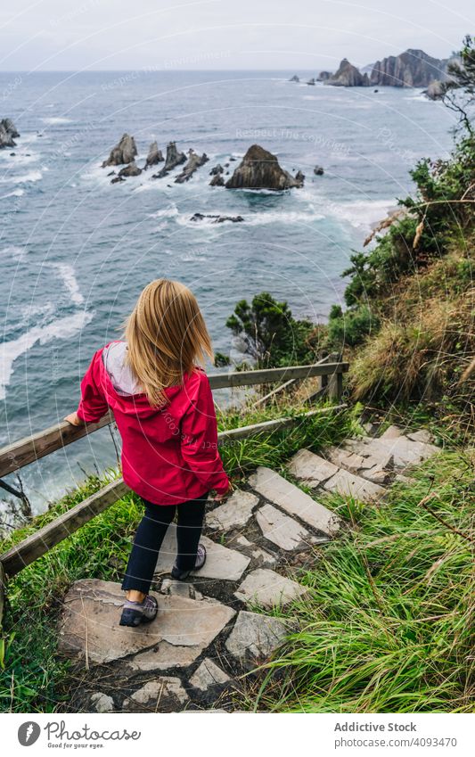 Woman walking down on stone steps leading down to foamy sea woman way water path active ocean coast wave vacation seaside walkway seashore nature travel scenery