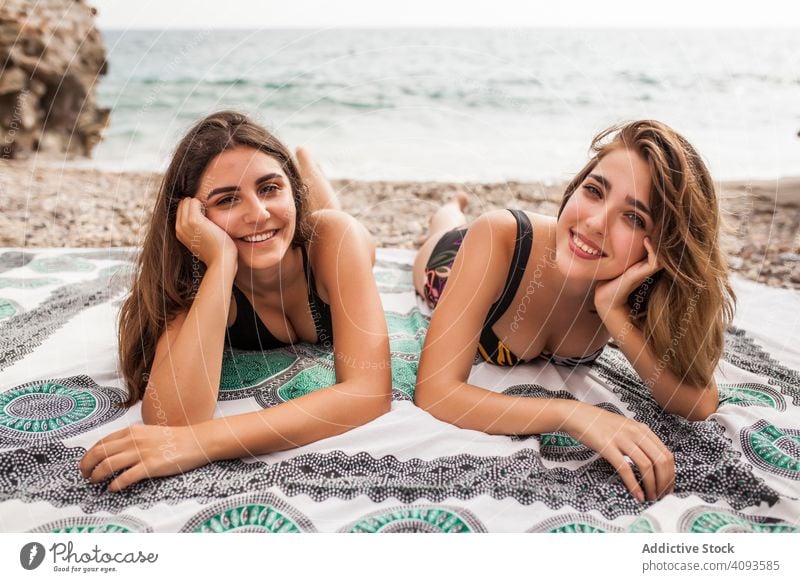 Girlfriends lying on beach relaxing women together vacation resort best friend holidays tourism friendship female happy cheerful pretty attractive positive