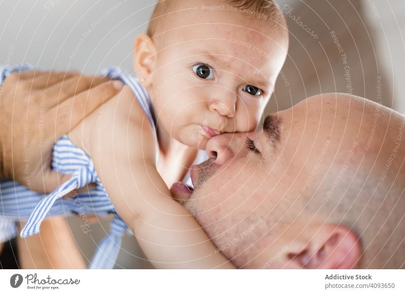 Father kissing baby on cheek father love family child adult man happy childhood kid parent toddler smile closed eyes joy affection closeness bonding fondness