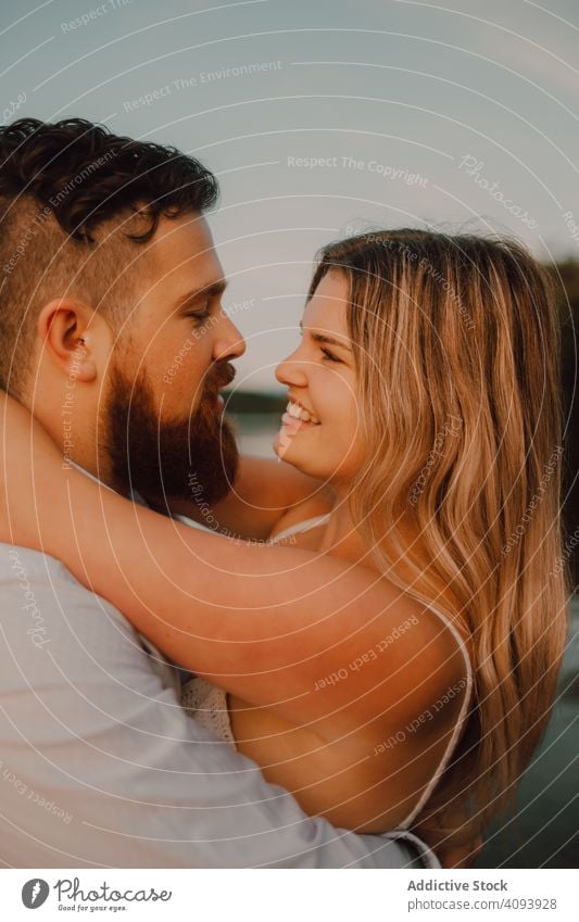 Loving man carrying happy woman on hands on shore couple lake hug love carrying on hands affection romance relationship nature summer gentle passion romantic