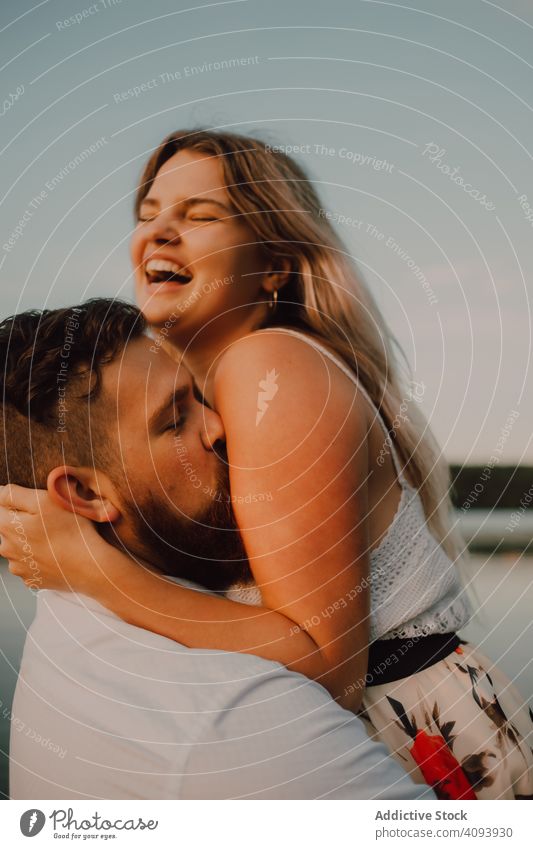 Loving man carrying happy woman on hands on shore couple lake hug love carrying on hands affection romance relationship nature summer gentle passion romantic