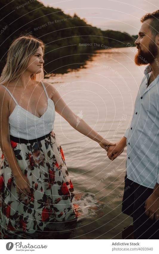 Loving couple standing ankle deep in water on beach hug love lake tender shore adorable embrace coast vacation nature honeymoon caress together affection