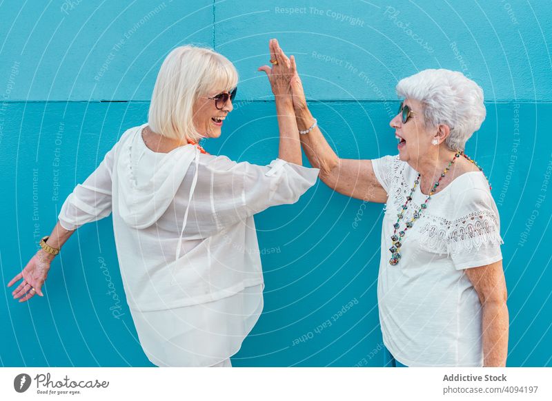 Aged female friends giving high five aged senior women old elderly laughing positive optimistic cheerful celebrate greeting success happiness rejoice modern