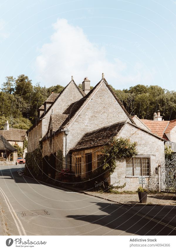 Town street with old cozy houses townscape village castle combe dorset travel destination tourism architecture building stone medieval historical embankment