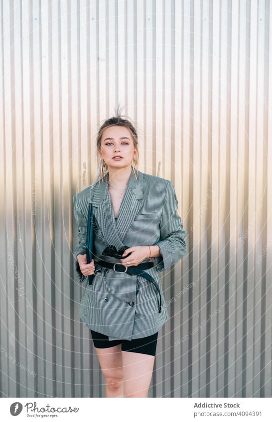 Woman with tablet in stylish suit standing nearby wall holding sunglasses businesswoman working using trendy communication manager career entrepreneur screen