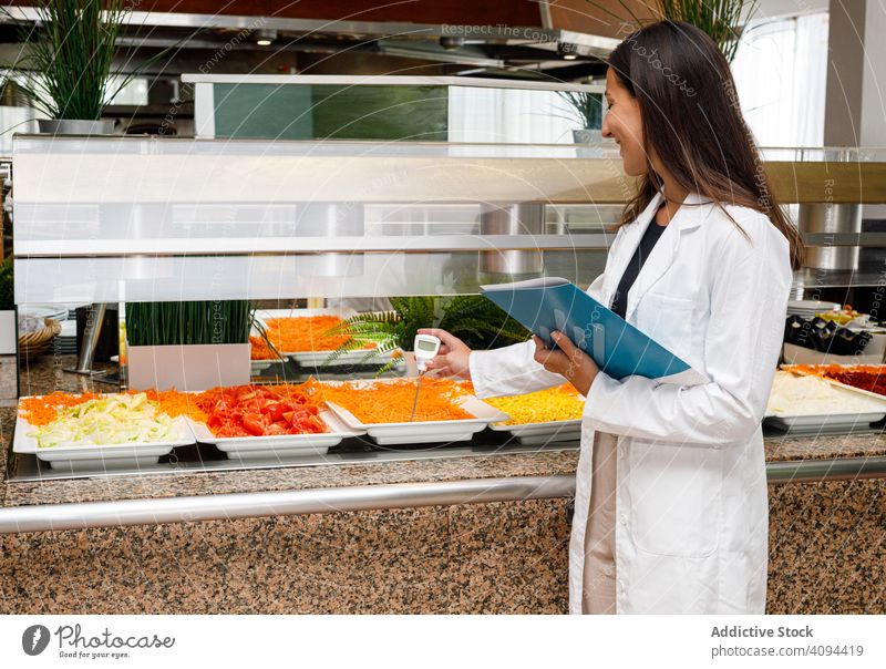 Adult employee checking food quality in canteen control test analysis showing report risk prevent product research measurement gadget expert chemical result