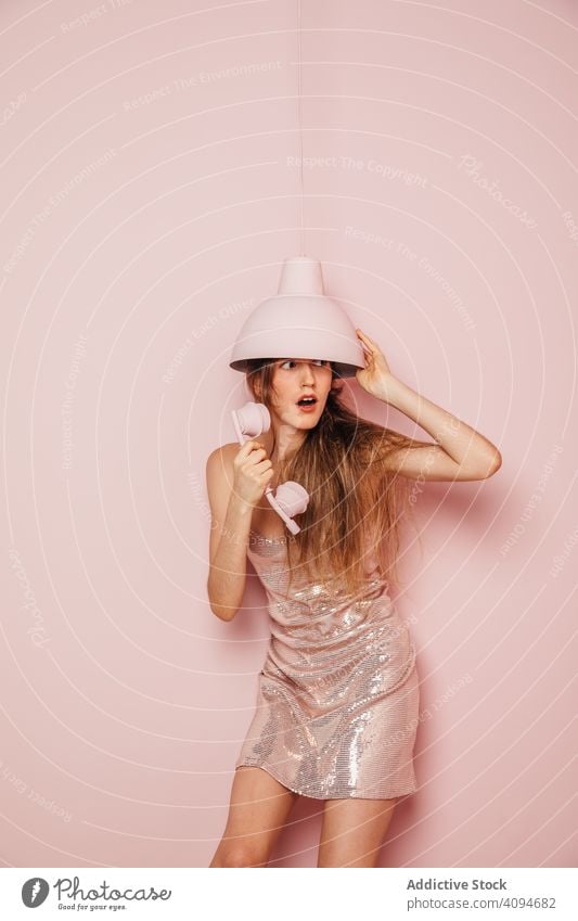 Fashion girl with a phone in her hand on a pink wall fancy impressed telephone gorgeous fashionable communication device hipster funny smile enjoy teenager