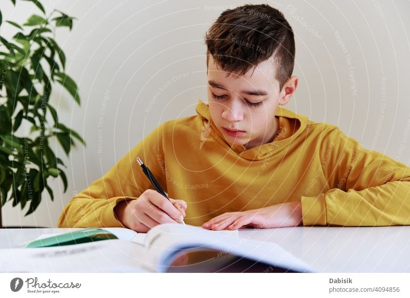 Teenage boy write homework at home. Education concept school writing studying education book person student people childhood caucasian desk young learning