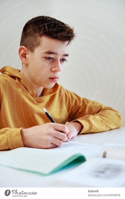 Teenage boy write homework at home. Education concept school writing studying education book person student people childhood caucasian desk young learning