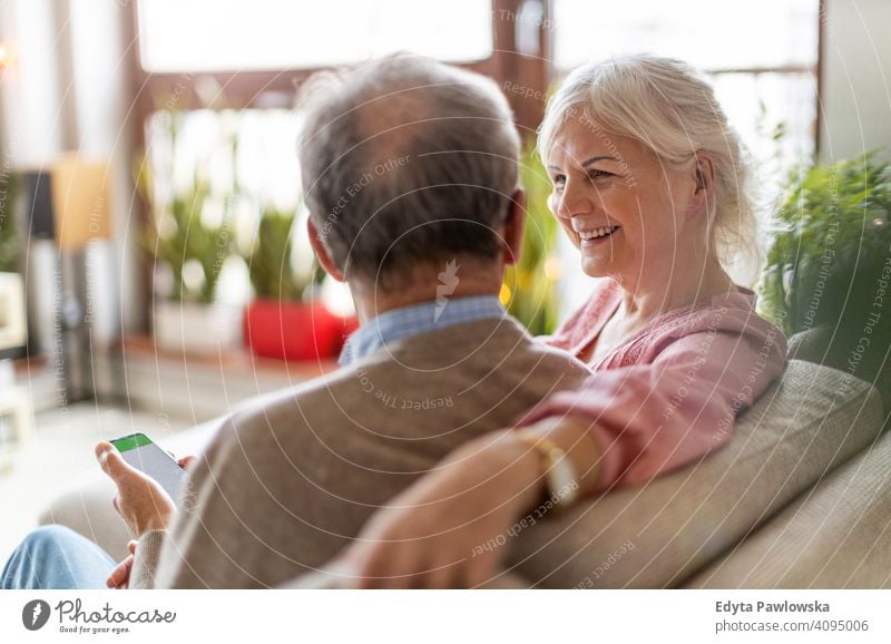 Portrait of a senior couple relaxing at home people woman adult mature casual attractive female smiling happy Caucasian toothy enjoying two people love