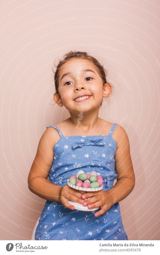 Happy child holding plate with mini chocolate eggs. april candy celebration childhood colorful copy space decoration dessert easter festive food fun happy