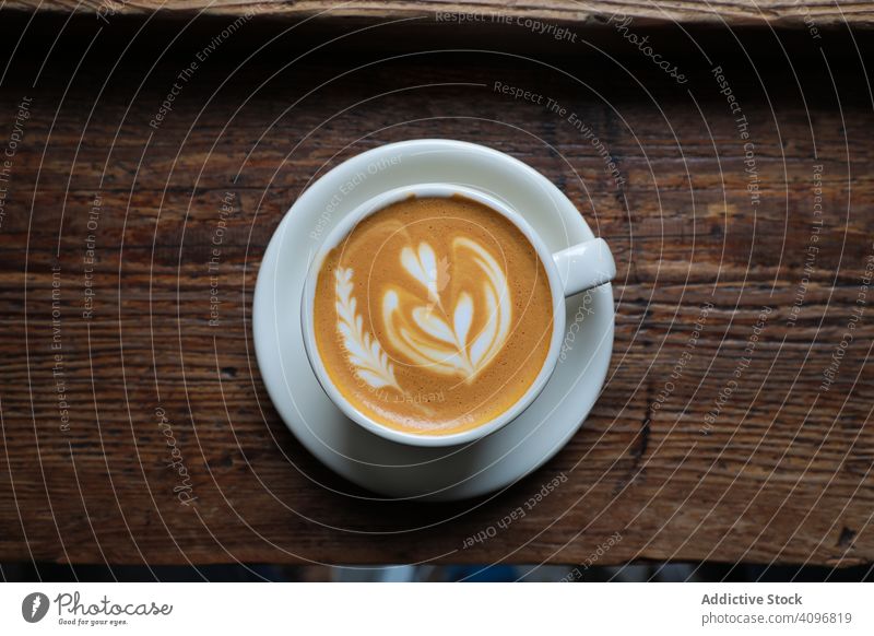 Delicious hot coffee with latte art cappuccino cup froth cafe coffee shop aroma delicious drink foam milk beverage table served heart rosetta shaped white