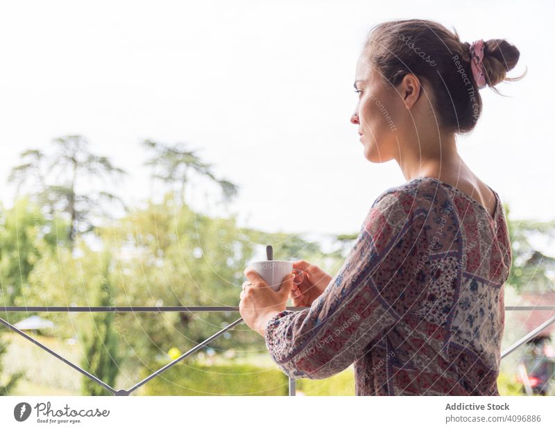 Girl in a shirt with a cup of coffee or tea looking out the window in the morning woman pretty awake joy girl beauty indoors view home rest lifestyle beautiful