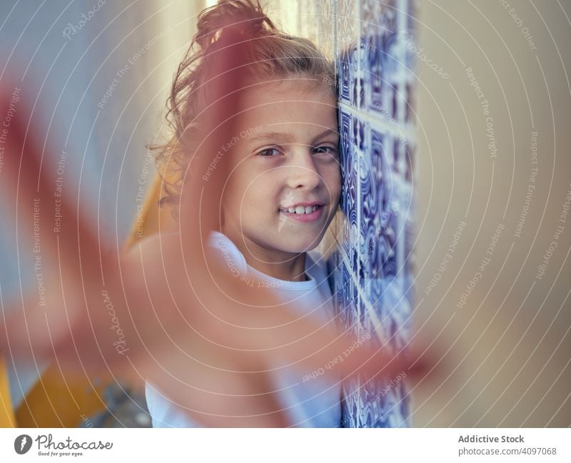 Smiling kid standing on street child smile portugal content lean wall happy childhood sunlight free time cheerful young relax rest vacation holiday summer