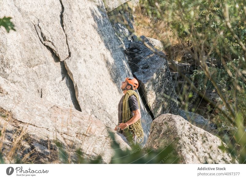 A rock climber is staring at the mountain man sport mountaineering adrenaline aspiration difficult strength strong athletic person active sky adventure nature