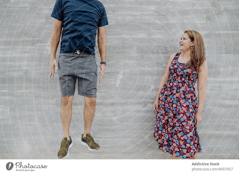 Excited woman looking at man jumping high couple fun cheerful excited playful wall people crazy successful content joyful triumph casual achievement enjoying