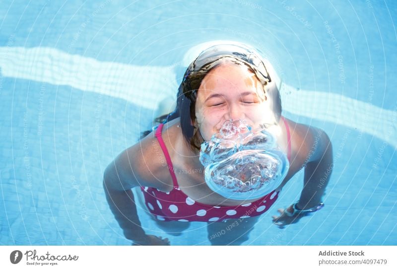 Happy teenager emerging from pool water swim bubble blow plunge resort fun play girl closed eyes emerge happy glad pleasure activity clean clear transparent joy