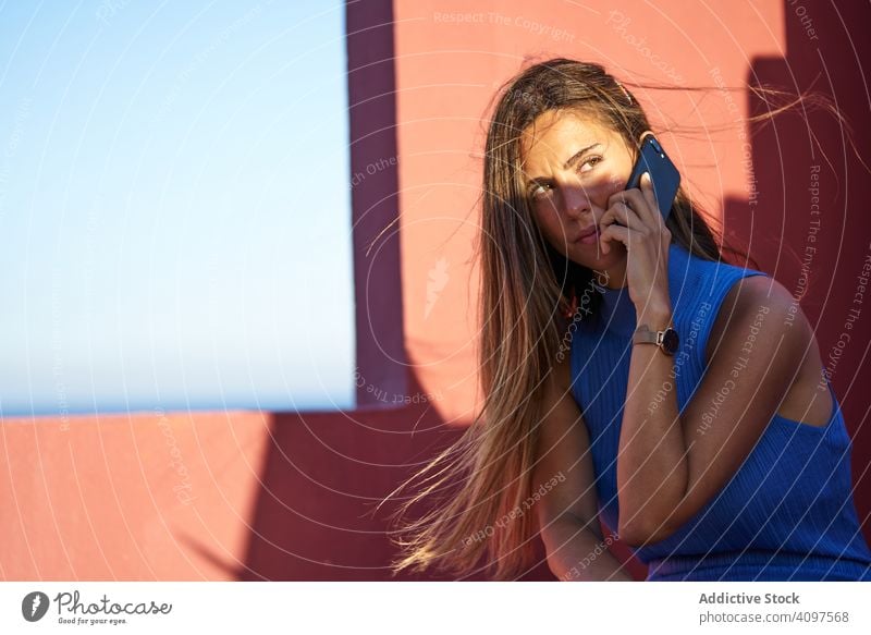 Woman on a red building using smartphone woman elegant construction mobile phone dress sitting step structure geometric architecture facade wall abstract