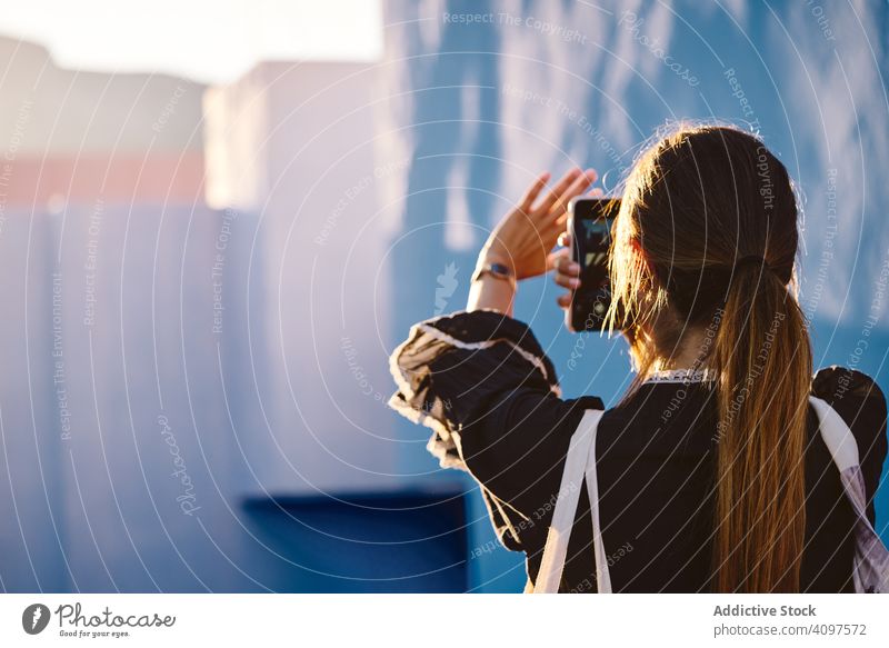 Woman on a blue building taking a picture woman construction structure geometric architecture urban facade wall abstract exterior innovation modern apartment