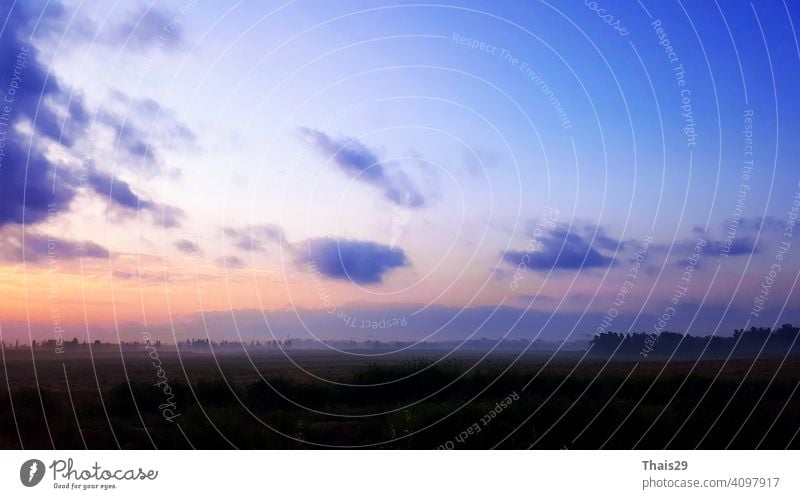 Natural Sunset Sunrise Over Field Or Meadow. Bright Dramatic Sky And Dark Ground. Countryside Sun Over Skyline, Horizon. Cold Colours. abstract background