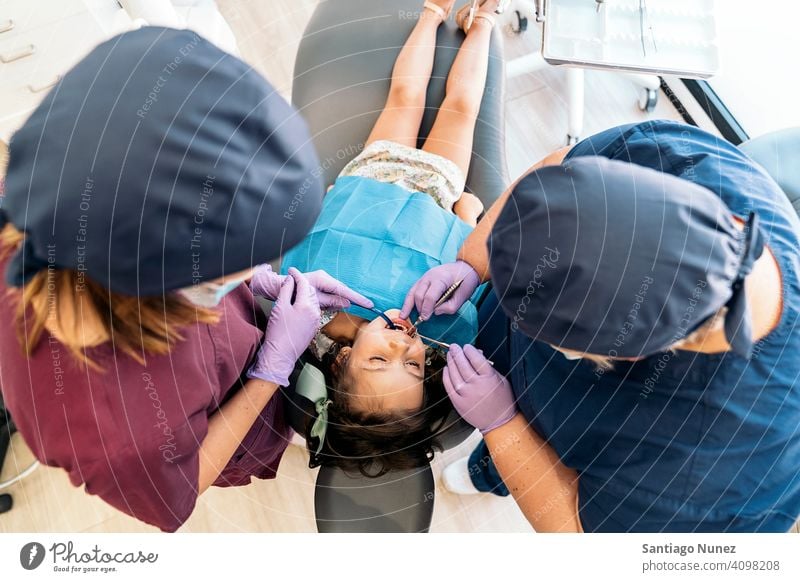 Young Girl During Checkup in Dentist examining top view kid girl young looking up dentist clinic dental clinic patient lying smile smiling health care equipment