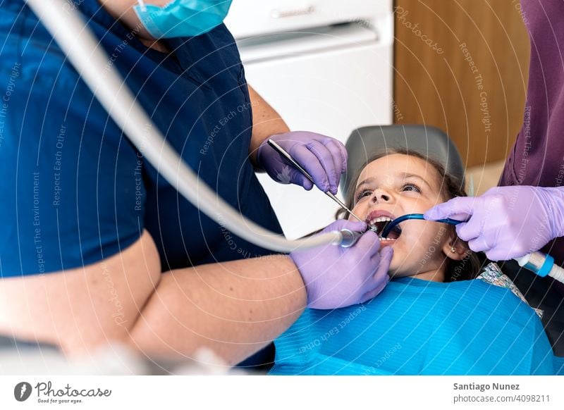 Young Girl In Dentist cleaning dental tools examining front view kid girl young looking up dentist clinic dental clinic patient lying health care equipment