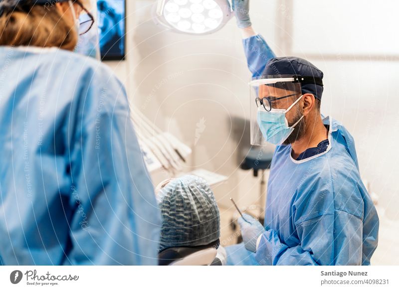 Dental Clinic Worker With Face Mask hair net plastic mask back view man woman patient sitting looking examining dentist clinic dental clinic lying health care