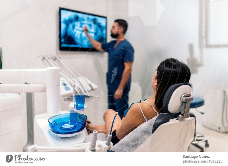 Dental Clinic Worker Showing X-ray x ray show showing patient room back view man woman standing looking examining dentist clinic dental clinic lying health care