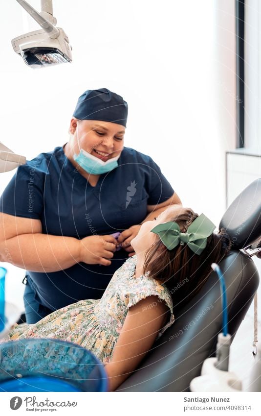 Happy Dental Clinic Worker and Little Girl looking at each other woman worker patient little girl dental clinic smile smiling two people side view standing kid